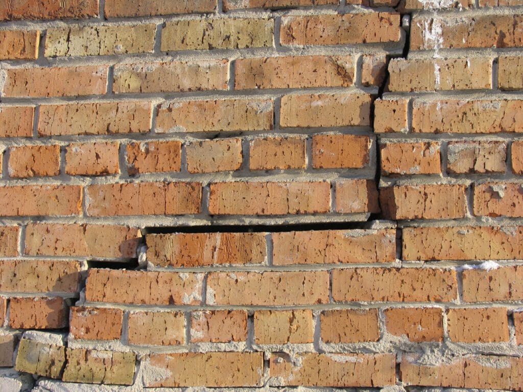 Cracked brick wall with damage.