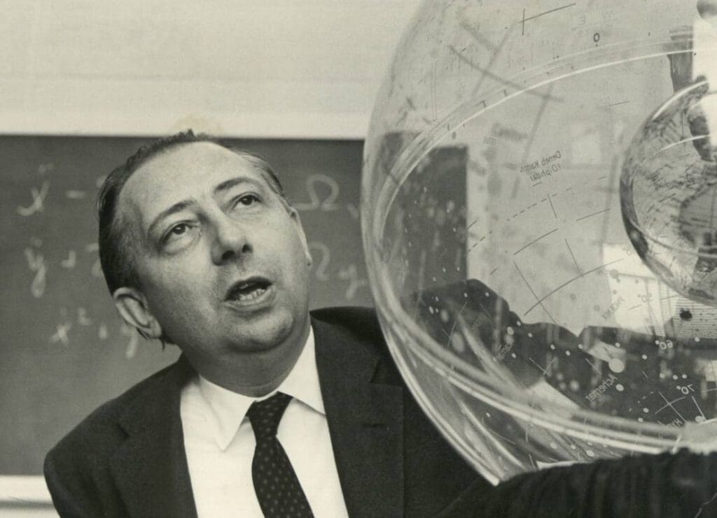 Black and white photo of a man with a celestial globe.