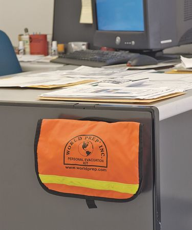 A orange bag on the side of an office desk.