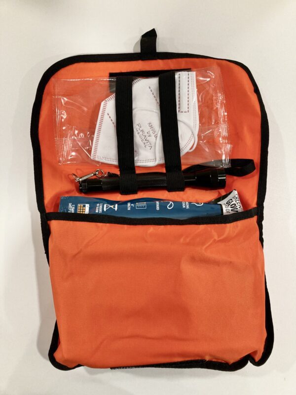 A bag with an orange cover and some items inside