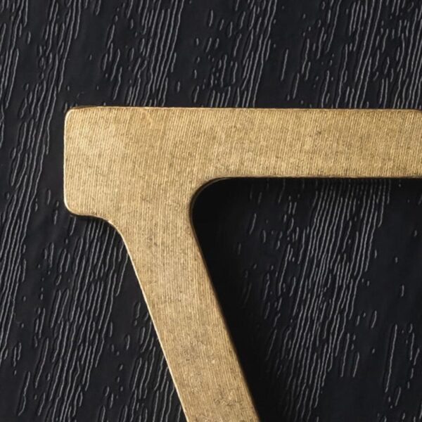 A close up of the letter t on top of a table.
