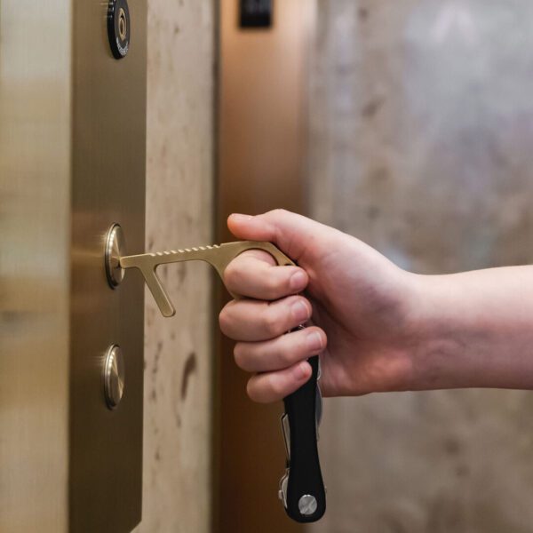 A person is holding onto the handle of an elevator.