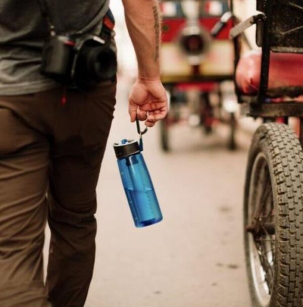 A man holding onto a blue water bottle