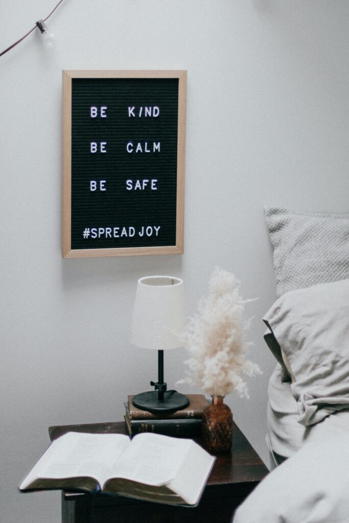 A lamp and some pillows on top of a bed.