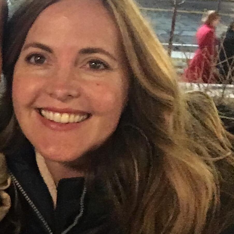 A woman smiling for the camera with long hair.